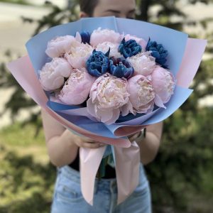 A stunning bouquet named "Blissful Blooms" features a blend of delicate peonies and vibrant blue tulips. The peonies showcase their lush petals in various shades, while the blue tulips add a captivating touch of color. This harmonious combination creates a visually striking and elegant arrangement, perfect for adding a touch of beauty and charm to any occasion.