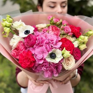 Vibrant and diverse floral arrangement featuring Hydrangea, anemones, carnations, roses, spray roses, and lisianthus