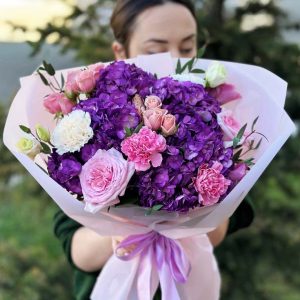 A captivating bouquet named "Elegant Garden Medley" showcasing hydrangeas, roses, lisianthus, spray roses, dianthus, and eucalyptus in a beautifully arranged garden-inspired bouquet.