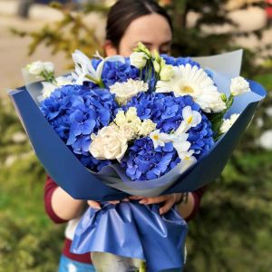 A close-up view of the "Harmony in Blooms" bouquet, showcasing the captivating beauty of hydrangeas, irises, roses, lisianthus, gerberas, and spray roses, harmoniously arranged to create a stunning floral symphony.