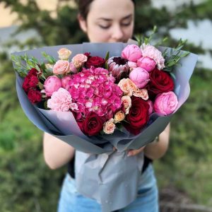 A close-up view of the "Elegance in Blossom" bouquet, highlighting the exquisite beauty of hydrangeas, spray roses, roses, dianthus, eucalyptus, and protea, elegantly arranged in a bouquet.