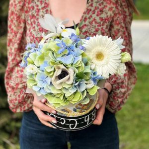 A beautiful Elegant Floral Box arrangement featuring hydrangeas, anemones, gerberas, irises, and delphiniums, priced at $65. Ideal for gifting on special occasions.