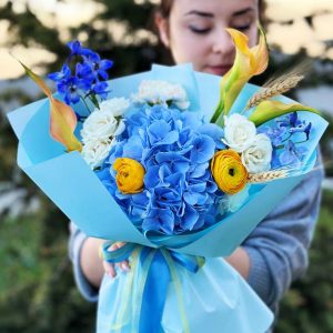 zure Delphinium Delight Bouquet: An elegant combination of azure blue delphiniums, lilies, ranunculus, and spray roses.