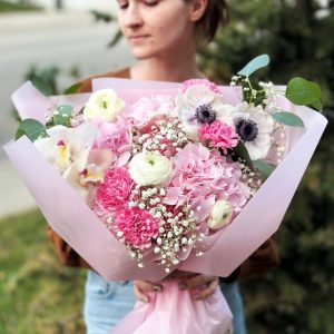 A mesmerizing bouquet named "Enchanted Garden Symphony" featuring hydrangeas, dianthus, gypsophila, anemones, ranunculus, orchids, and eucalyptus. Ideal for special occasions and emotional expressions.
