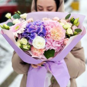 Image of the "Radiant Garden Medley" bouquet, a vibrant and elegant floral arrangement featuring hydrangeas, gerbera daisies, ranunculus, dianthus, lisianthus, spray roses, and fragrant eucalyptus, perfect for celebrating special occasions or conveying heartfelt admiration.