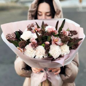 Image of the "Crimson Tulip Serenade" bouquet, featuring a vibrant collection of crimson tulips, carnations, and skimmia, perfect for romantic gestures, anniversaries, and expressing heartfelt love and admiration.