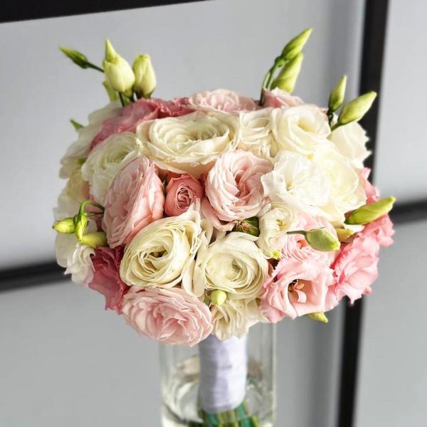 Image of the "Eternal Elegance" wedding bouquet, showcasing a beautiful arrangement of ivory, blush pink, and deep red roses. The lush greenery and delicate blooms create a visually enchanting and romantic bouquet perfect for a bride's special day.