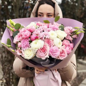 Image of the "Radiant Blossom Harmony Bouquet" showcasing a colorful blend of roses, chrysanthemums, ranunculus, lisianthus, spray roses, dianthus, and gypsophila. The lush eucalyptus foliage provides a vibrant and balanced arrangement, perfect for special occasions.