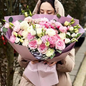 Image of the "Enchanting Rose Medley Bouquet" featuring a vibrant mix of roses, lisianthus, ranunculus, and other blooms. The varied colors and textures create a visually stunning arrangement, perfect for special celebrations.