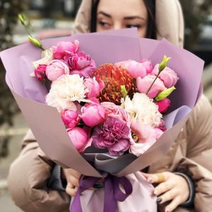 Captivating image of the "Ethereal Elegance Ensemble" showcasing leucospermum, lisianthus, spray roses, and dianthus. The bouquet's unique combination of blooms creates an ethereal and sophisticated visual experience.