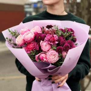 An image of the "Harmony in Bloom Bouquet" showcasing spray roses, protea, dianthus, chrysanthemums, and eucalyptus. The diverse blooms, varied textures, and fresh greenery create a harmonious and visually appealing floral arrangement.