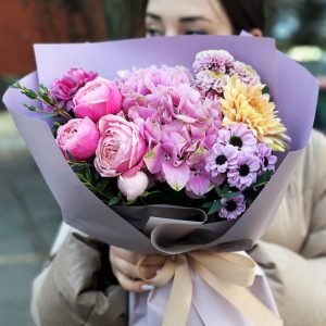 An image of the "Harmony Blossoms Bouquet," showcasing a delightful mix of hydrangeas, spray roses, chrysanthemums, and dianthus. The vibrant colors and varied textures create a visually stunning arrangement, perfect for bringing the beauty of nature indoors.