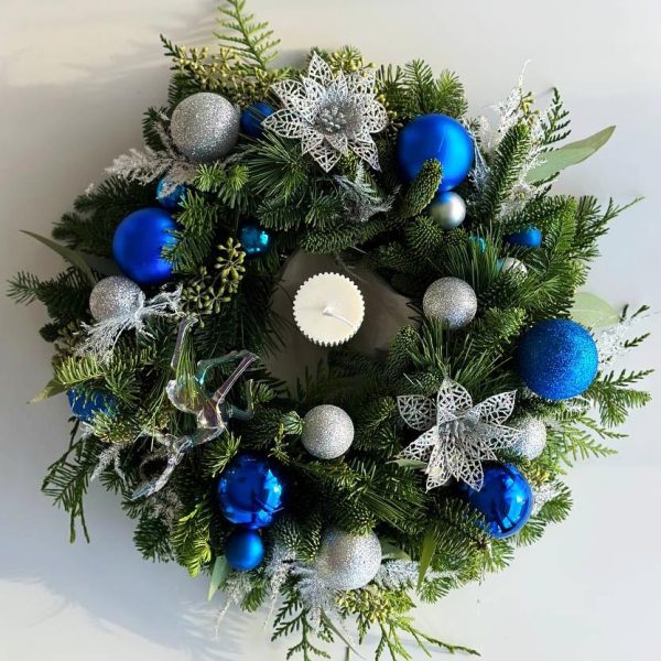Blue Winter Radiance: Table centerpiece with a festive Christmas candle and enchanting blue New Year's decorations, creating a captivating and festive atmosphere for your holiday dining experience.