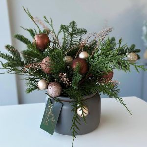 Evergreen Elegance: Christmas table centerpiece with a charming miniature Christmas tree and lush evergreen accents, creating a festive and inviting atmosphere for your holiday dining experience.