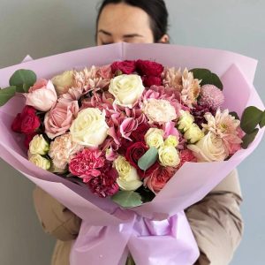 Eclectic Harmony: Multifaceted bouquet with hydrangeas, dianthus, roses, spray roses, chrysanthemums, and eucalyptus, creating a beautiful balance of colors and forms.