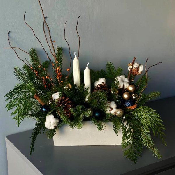 Winter Aesthetics: Table composition with pine, cones, and holiday ornaments, creating a festive mood.