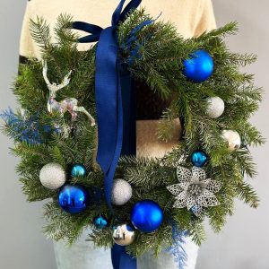 Winter Beauty: Pine wreath with blue and silver ornaments, creating a festive mood and an exquisite look.