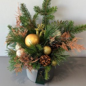 Festive Radiance: Christmas composition with pine on the table with cones and gold ornaments, creating a festive mood and an elegant look.