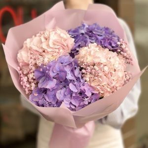 A captivating bouquet featuring delicate hydrangeas and baby's breath, arranged in a stunning display reminiscent of drifting clouds, perfect for gifting or adding a touch of elegance to any setting.