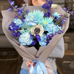 A beautiful bouquet titled "Charming Elegance," featuring soft blue chrysanthemum, carnations, and gorgeous delphinium.