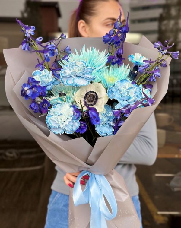 A beautiful bouquet titled "Charming Elegance," featuring soft blue chrysanthemum, carnations, and gorgeous delphinium.