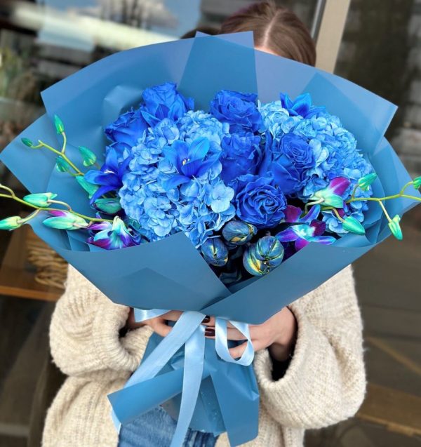 A striking bouquet titled "Sapphire Splash," featuring deep blue roses, vibrant tulips, and delicate hydrangeas, elegantly arranged and wrapped in blue paper.