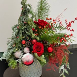 Christmas arrangement "Season's Greetings" featuring red roses, ilex berries, and lush greenery, capturing the festive spirit of the season.