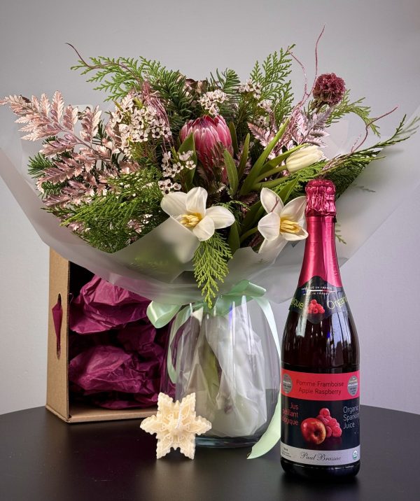 "Christmas gift set featuring seasonal flowers with a vase, a sparkling beverage, and candles, perfect for holiday celebrations."