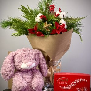 Christmas gift set with a red tulip and ilex arrangement, a festive toy, and candies, perfect for holiday gifting.