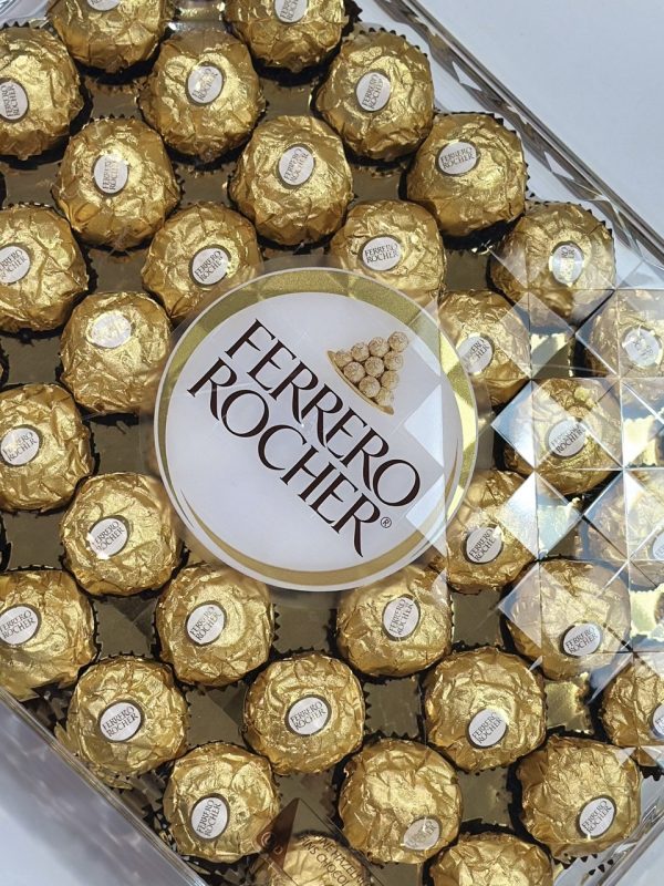 Ferrero Rocher chocolates featuring a hazelnut center coated in chocolate and crunchy hazelnut pieces, elegantly wrapped for gifting.