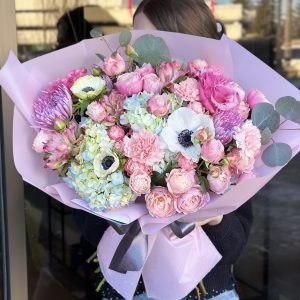 A luxurious floral arrangement called "Velvet Garden," featuring hydrangeas, spray roses, carnations, and anemones, creating an elegant and sophisticated display of rich textures and colors.