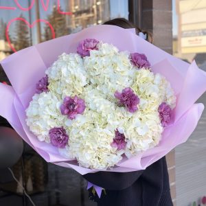 A serene floral arrangement called "Gentle Grace," featuring soft hydrangeas and carnations, creating a delicate and elegant display of subtle hues and textures.