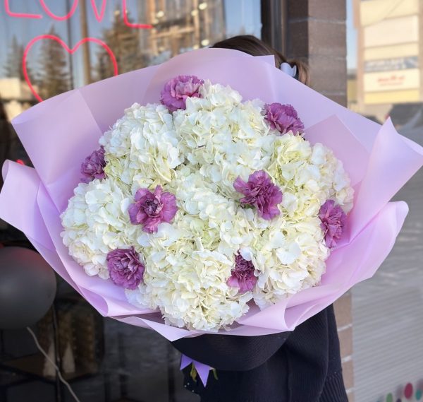 A serene floral arrangement called "Gentle Grace," featuring soft hydrangeas and carnations, creating a delicate and elegant display of subtle hues and textures.