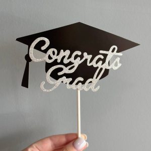 Mini black graduation cap with tassel added to a bouquet for graduation celebration.